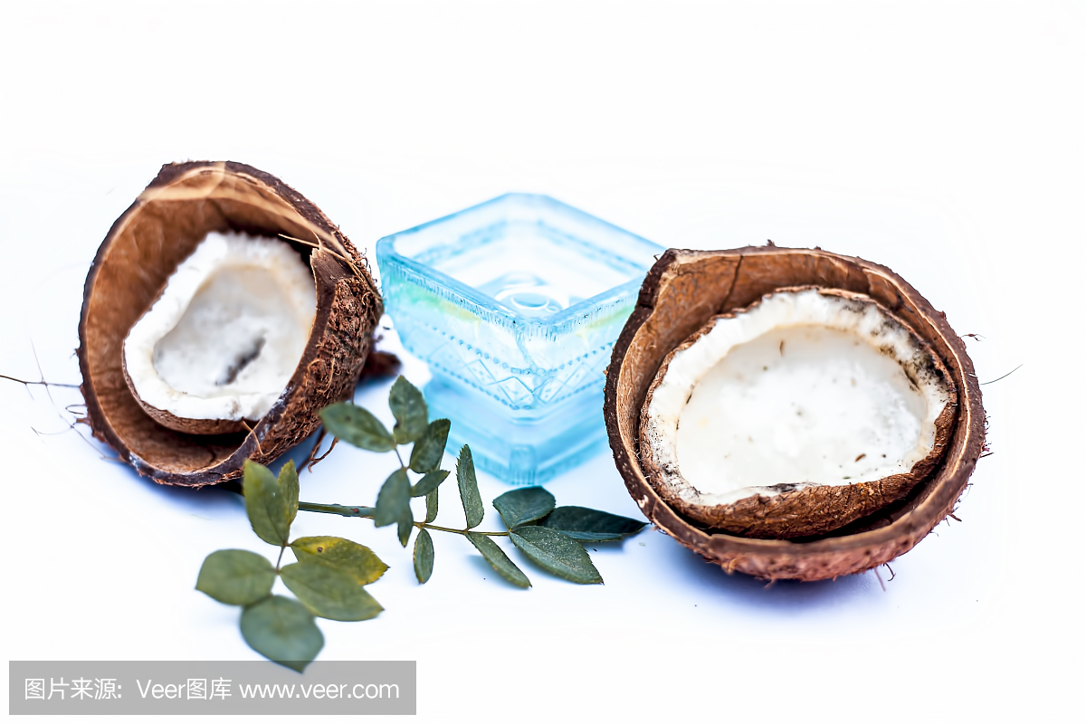 近距離的原料有機(jī)椰子油與原料椰子隔離在白色的藍(lán)色碗。